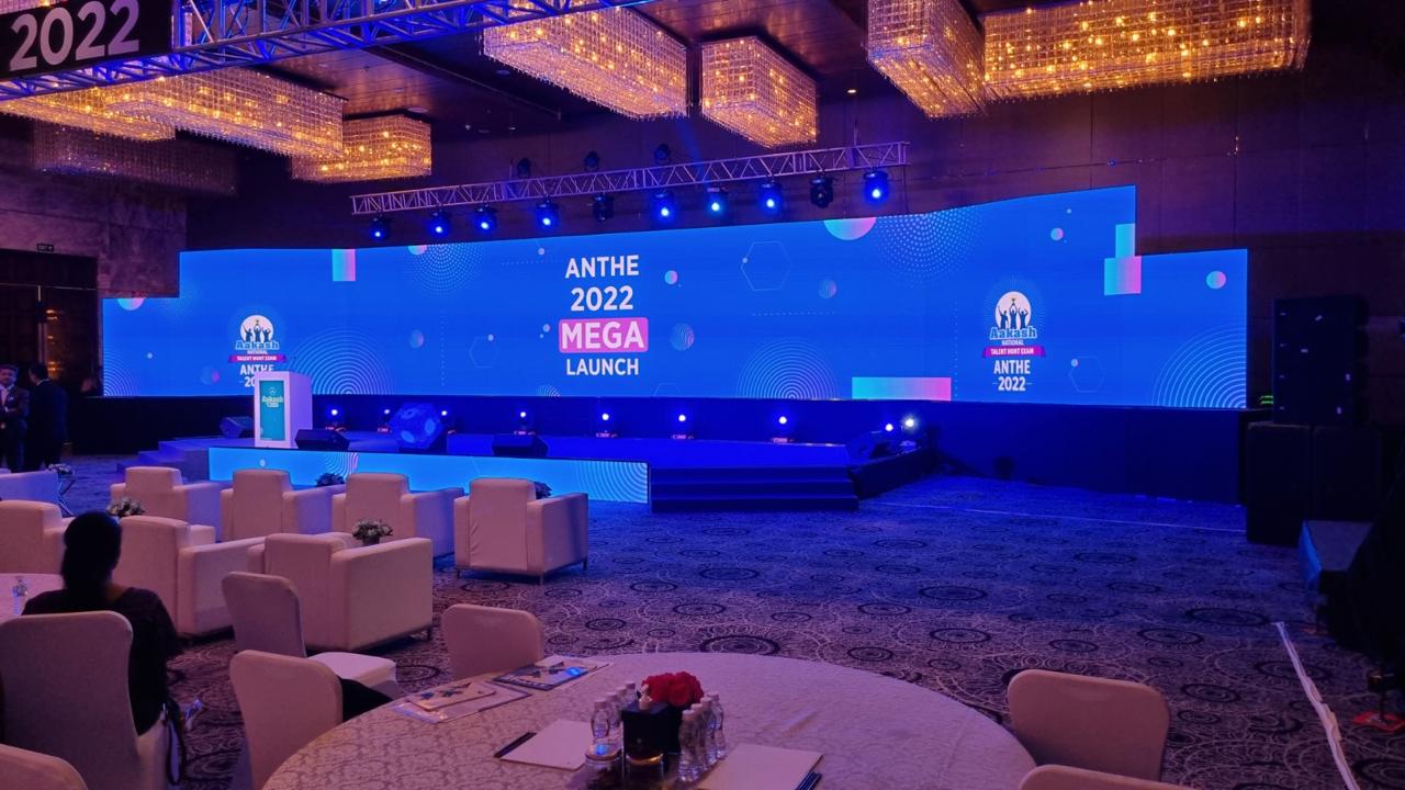 ANTHE 2022 Mega Launch stage lit in blue with lounge seating and the launch key art across the LED wall